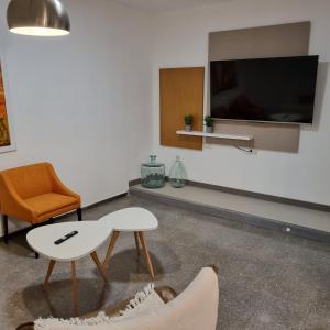 sala de estar con TV, mesa y silla en Departamento Francisco 2, en San Juan