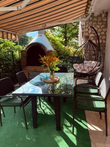 a table and chairs on a patio with a pizza oven at Vikendica Hondo Boracko jezero in Jezero