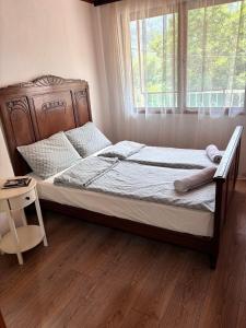 a bedroom with a bed with a wooden frame and a window at Vikendica Hondo Boracko jezero in Jezero