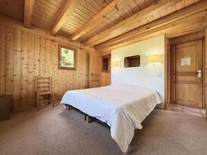 une chambre avec un lit dans une pièce en bois dans l'établissement Chalet Cristal - Chalet de charme avec sauna et superbe vue sur le MOnt Charvin et les Aravis MAE-1154, à Crest-Voland