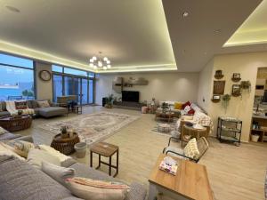 Una gran sala de estar con sofás y una mesa. en Soso beach villa, en Durat Alarous