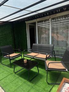 a patio with two chairs and a table on the grass at Dragovca Apartment in Prizren +8 photos