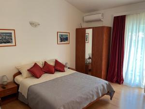 a bedroom with a large bed with red pillows at Rooms Raguž in Neum