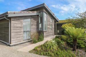 een klein houten huis met een garage bij Una, Lodge 70 in St Ives