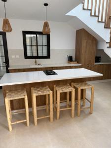 a kitchen with a large table and stools at Villa Eden Djerba in Djerba