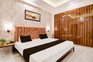 a bedroom with a large bed and a shower at Hotel O VELMORA HOTEL in Lucknow +23 photos