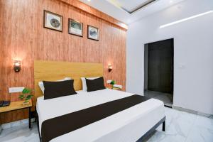 ラクナウにあるHotel O VELMORA HOTELの大きなベッドと木製の壁が備わるベッドルーム1室が備わります。