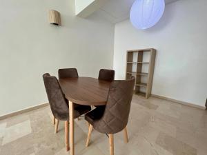 a wooden table with four chairs in a room at Casablanca Central Suites - Casa Voyageurs in Casablanca +6 photos