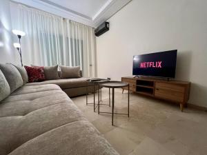 a living room with a couch and a tv at Casablanca Central Suites - Casa Voyageurs in Casablanca