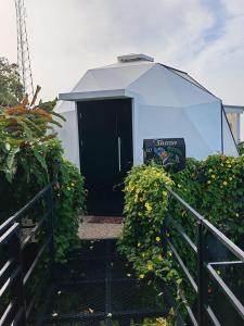 a building with a black door and some plants at Sunrise Hill Glamping in San Juan