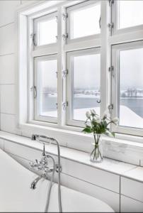 Un baño con lavabo y dos ventanas. en Summer place by the river, en Drammen