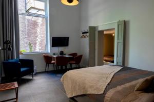 a bedroom with a bed and a table with chairs at "In de Kloosterhof" Gratis privé parkeren in Assen