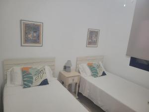 モハカルにあるApartamento La Perla Azulのテーブルと写真2枚が備わる客室内のベッド2台 +14枚の写真