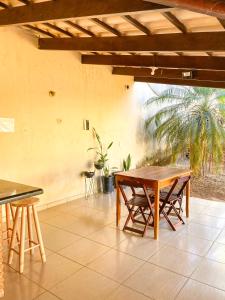 a patio with tables and chairs and a palm tree at Pousada Acessus Clássico - Cozinha e Lavanderia in Anápolis