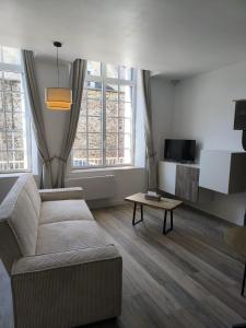 a living room with a couch and a coffee table at appartement proche de la Baie du Mont saint Michel in Saint-Jean-le-Thomas +25 photos