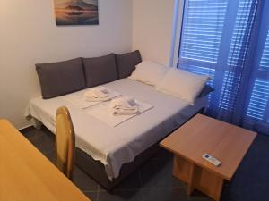 ein kleines Zimmer mit einem Bett und einem Tisch in der Unterkunft Apartman zarok in Baška