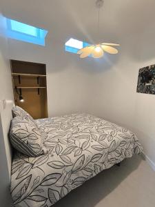 a bedroom with a bed and a ceiling fan at appartement proche de la Baie du Mont saint Michel in Saint-Jean-le-Thomas