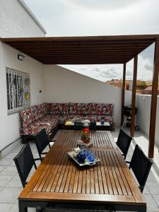 a living room with a couch and a table and chairs at Cozy Loft, Sunny Terrace in Nador