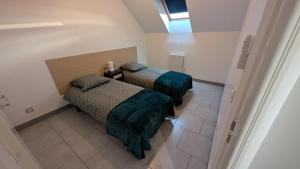 two beds in a small room with a window at Duplex avec Parking in Chassieu