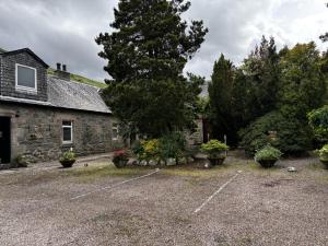 an old stone house with a parking lot at No4 Invereoch in Arrochar