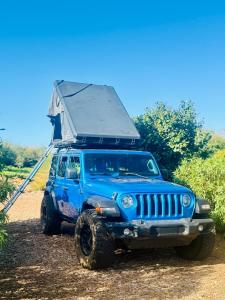 Gambar di galeri bagi Explore Maui's diverse campgrounds and uncover the island's beauty from fresh perspectives every day as you journey with Aloha Glamp's great jeep equipped with a rooftop tent di Paia