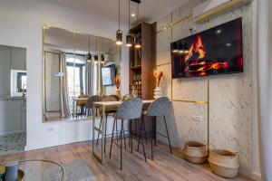 a kitchen with a bar with stools and a fireplace at Golden View - Breathtaking Location - City Center in Bucharest