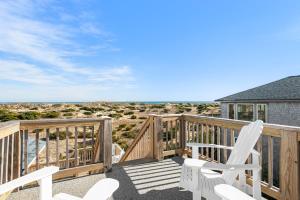 a deck with chairs and a view of the ocean at Sandpiper in Salvo