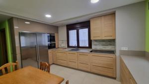 a kitchen with wooden cabinets and a wooden table and a dining room at A Casa de Chefa in San Ciprián