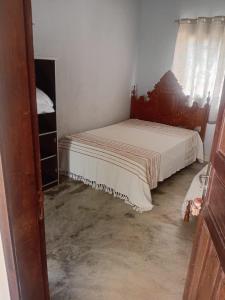 a small bedroom with a bed and a window at Suítes da Raquel Ype Amarelo in Alto Paraíso de Goiás
