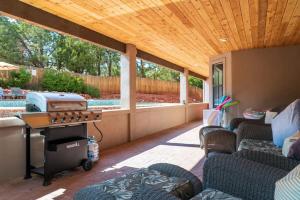 a backyard patio with a grill and chairs at Sedona Southwest Home with Views Pool and Spa for Family in Sedona +44 photos