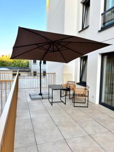 eine Terrasse mit einem schwarzen Sonnenschirm auf einem Balkon in der Unterkunft Studio 50 in Kielce