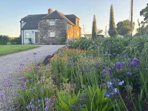 a garden in front of a house with flowers at The Shepherd's Lodge in Tullyallen