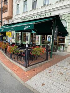 a restaurant with tables and chairs in front of a building at City Center Apartman Nagykanizsa in Nagykanizsa