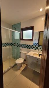a bathroom with a toilet and a sink and a shower at Turtle house 1 in Búzios +5 photos