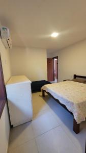a room with a bed and a refrigerator in it at Turtle house 1 in Búzios
