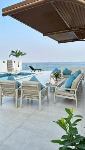 a patio with chairs and a table and a pool at Seascape Villa Marine in Fujairah +29 photos