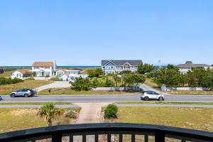 a view of a street with houses and cars on the road at Savannah Dawn in Southern Shores