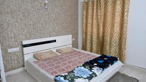 Dormitorio pequeño con cama con manta rosa en Sterling East Apartment, en Bangalore