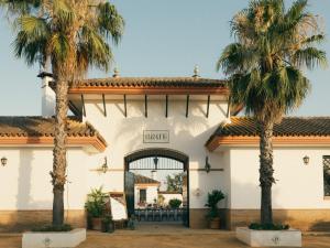 two palm trees in front of a building at Finca Orate in Mairena del Alcor