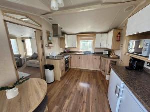 eine große Küche mit Holzböden und einer Arbeitsplatte in der Unterkunft Meadow Lakes 76 - sleeps 6 with a bath - Golden Palm Resort - Meadow Lakes Caravan & Lodge Hire in Chapel Saint Leonards