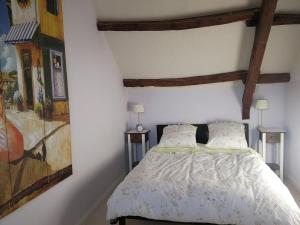 a bedroom with a bed and a painting on the wall at Maison Bretagne in Bourseul