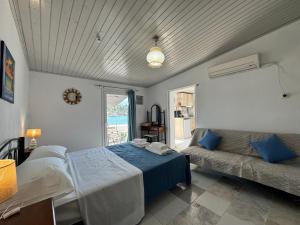 a bedroom with two beds and a couch in it at Riva Blue Silence -Seafront Retreat in Poseidónion +8 photos