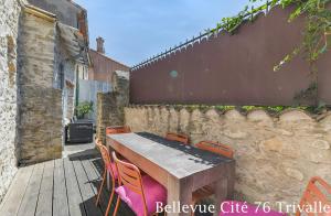 a wooden table and chairs on a wooden deck at Les Bellevue Cité Trivalle, Cité 500m, free private car park on demand, free public car park 200m, aircon, WIFI, Cité view terrace in Carcassonne