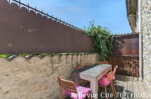 a table and chairs on a patio next to a wall at Les Bellevue Cité Trivalle, Cité 500m, free private car park on demand, free public car park 200m, aircon, WIFI, Cité view terrace in Carcassonne