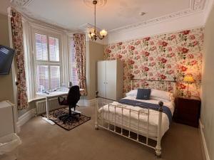 a bedroom with a bed and a desk and a refrigerator at The Mayfair guest house self catering in Southampton