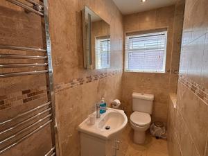 a bathroom with a sink and a toilet and a mirror at The Mayfair guest house self catering in Southampton +86 photos