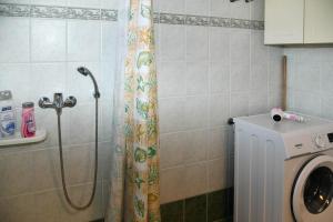 a shower in a bathroom with a washing machine at 50 Steps From the Sea in Lefkimmi