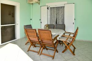 a dining room with a table and four chairs at 50 Steps From the Sea in Lefkimmi