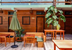 ein Restaurant mit Tischen und einem grünen Sonnenschirm in der Unterkunft Hippie Fish Hostal in Holbox