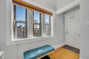 an empty room with a blue bench and windows at Steps to the Lakefront! This Uptown Beauty is Everything You Need for a Perfect Chicago Getaway condo in Chicago